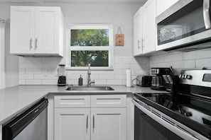 Enjoy cooking in this well-equipped kitchen with a refrigerator, dishwasher, stove, and microwave.