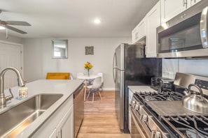 Enjoy cooking in the fully equipped kitchen with a refrigerator, microwave, and stove, and dine at the adjacent table and chairs.