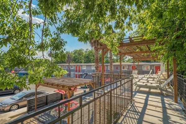 Relax in a serene outdoor space with a shaded seating area and staircase leading to an upper level.