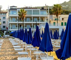 Praia particular, areia branca, espreguiçadeiras, guarda-sóis 