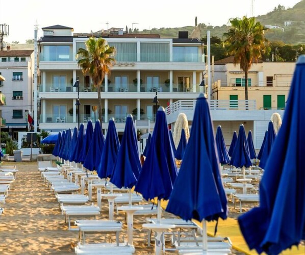 Playa privada, playa de arena blanca, camastros y sombrillas