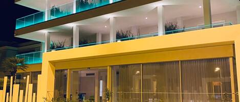 A multi-story hotel with balconies and large windows.