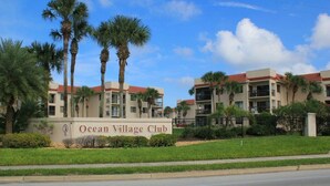 Een meerlaags gebouw met een bord waarop staat 'Ocean Village Club'.
