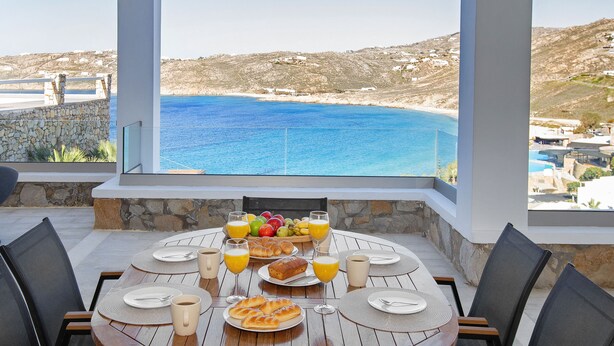 Ett dukat bord för frukost med utsikt över havet.