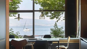 Un comedor moderno con vistas al mar y un velero.