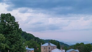 A stone building with a large central tower, a covered outdoor seating area, and a hot tub. - Dandy Villas Nymfaio Snowfairy (Amyntaio)
