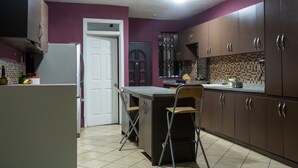 Una cocina con una isla central, un refrigerador y armarios.