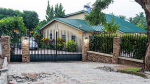 Propiedad residencial privada con acceso restringido, camino de entrada pavimentado y muros de piedra.
