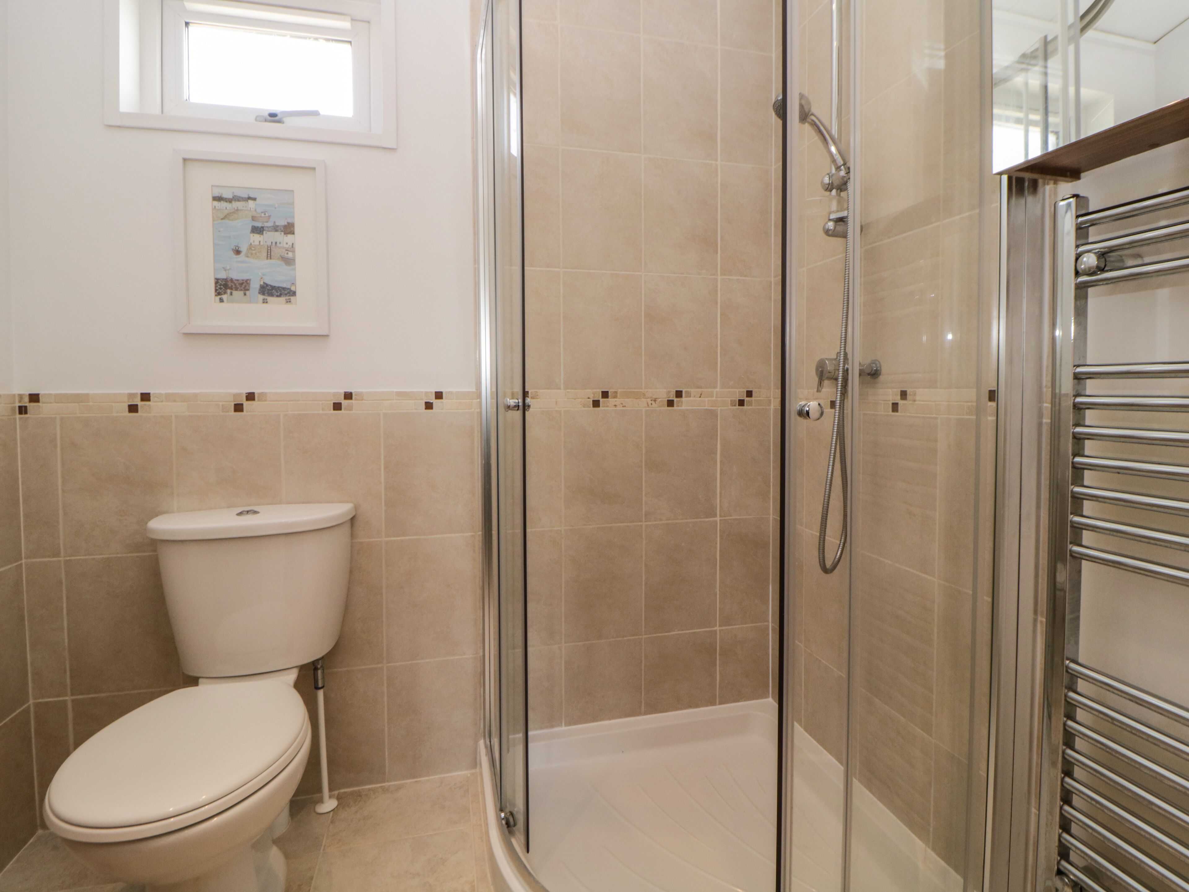 Un baño con ducha de mampara, inodoro y bañera.