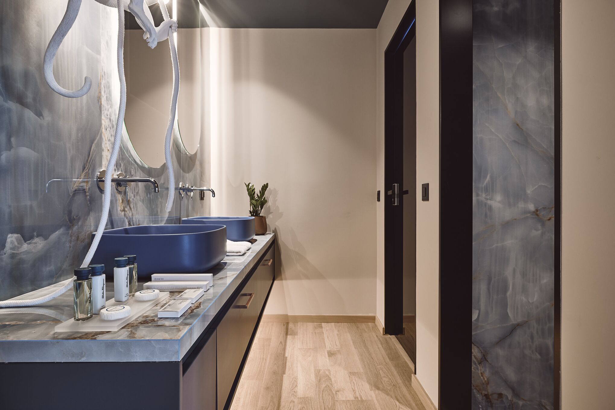 Un bagno moderno con due ampi lavabi, uno specchio e un porta asciugamani.