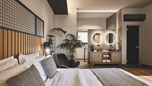 Un dormitorio moderno con una cama grande, un escritorio y un espejo.