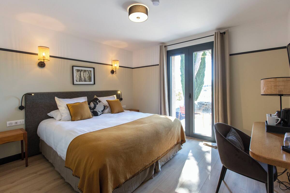 Une chambre d’hôtel avec un grand lit, un bureau et une vue sur l’extérieur.