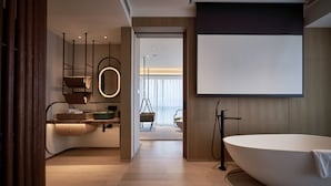 Un baño moderno con una bañera independiente, un tocador con espejo y un ventanal que proporciona luz natural.