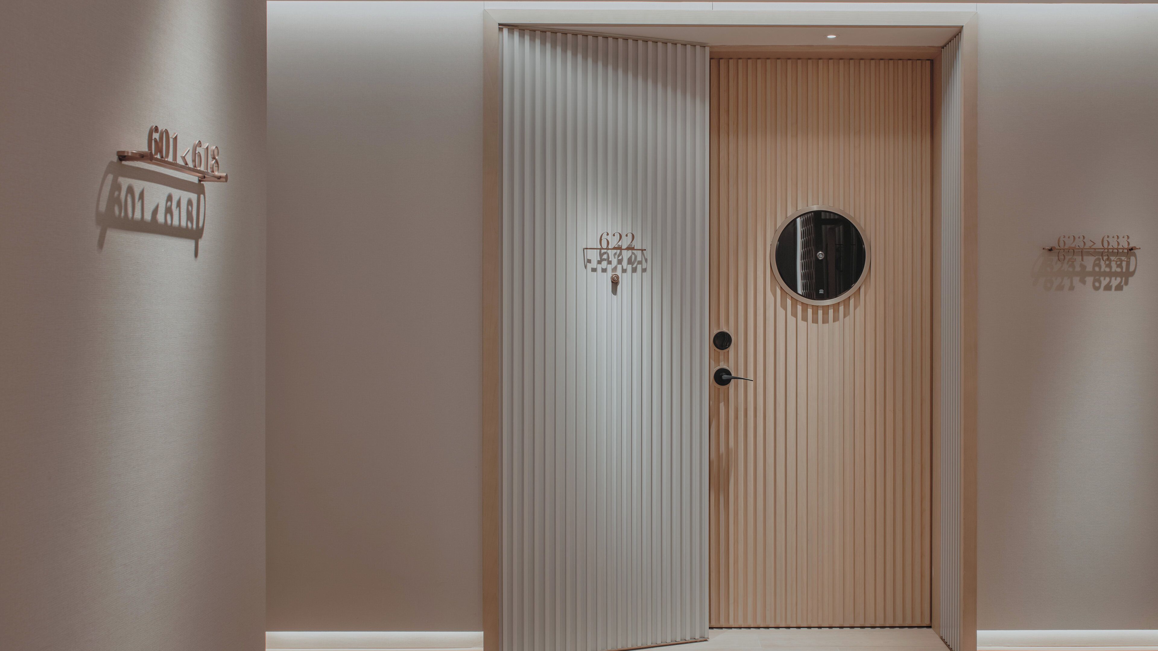 Una puerta con un estampado de rayas verticales y un ventanal circular.