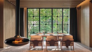 A dining area with a large window, a fire feature, and a tiled floor. - Hotel Indigo Hangzhou Uptown by IHG (Hangzhou)