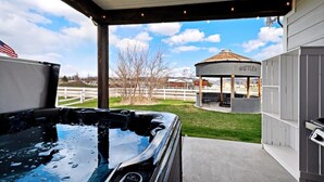 Ein Whirlpool mit Blick auf ein Gartenhaus und einen umzäunten Garten.