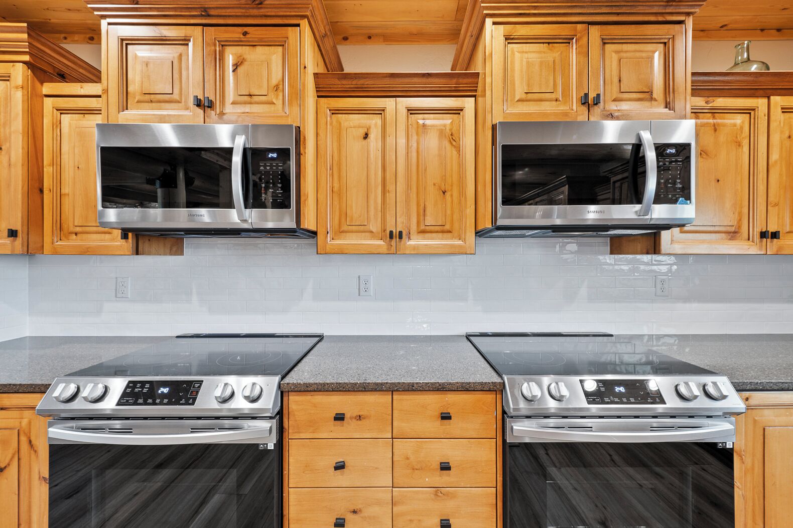A kitchen with wooden cabinets, stainless steel appliances, and a granite countertop.