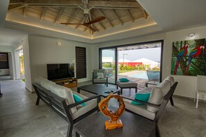 Ein modernes Wohnzimmer mit Fernseher, Sofas und einem Couchtisch.