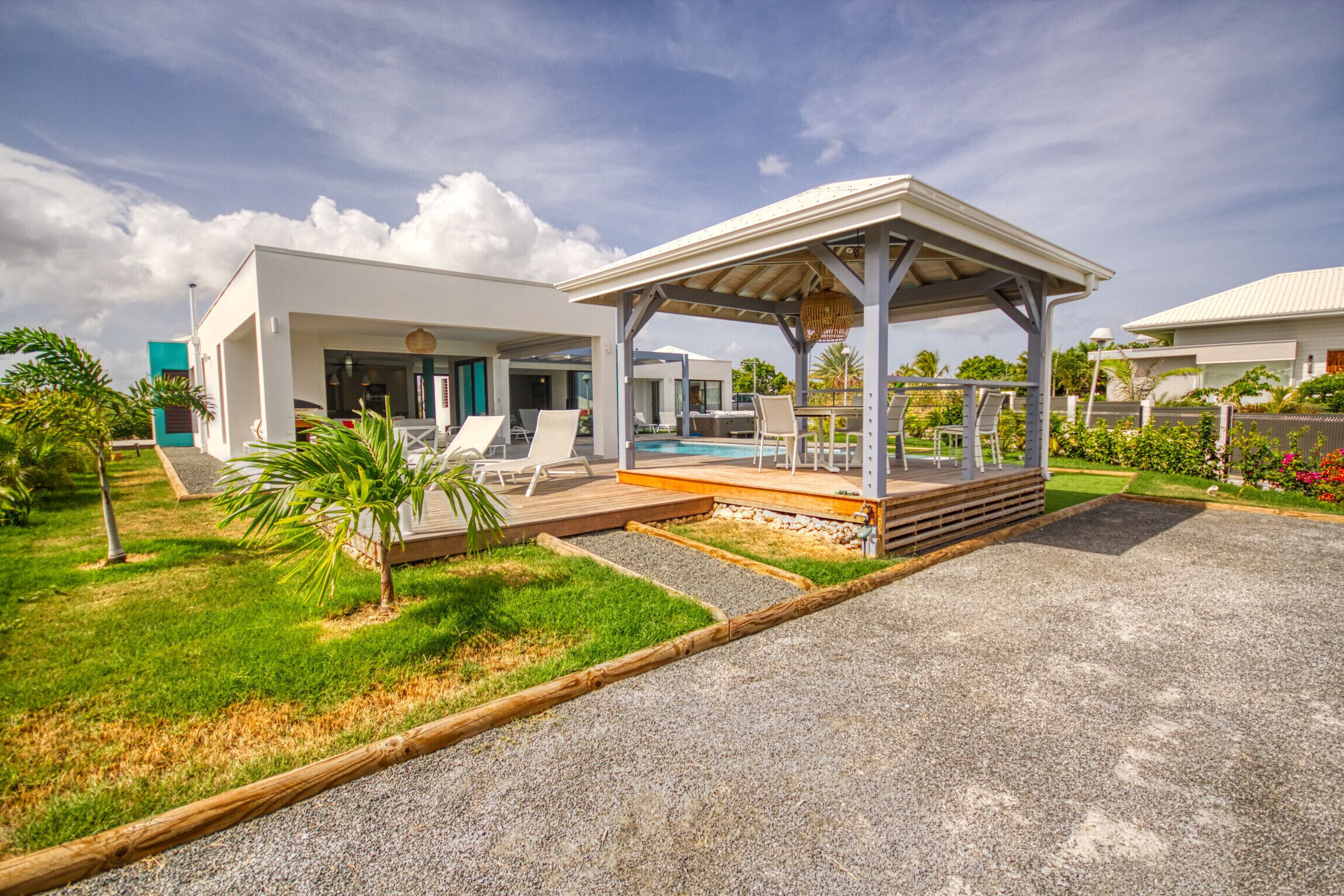 Ein modernes Resort mit Pool, Sitzgelegenheiten im Freien und einer überdachten Terrasse.