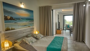 A modern bedroom with a large bed, a painting of a beach, and a view to a balcony. - Sea View Villa with Pool & Hot Tub - Sleeps 8 (Saint-François)