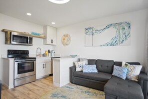 Live comfortably in this stylish space with a fully equipped kitchen, sofa, and artwork-adorned walls.