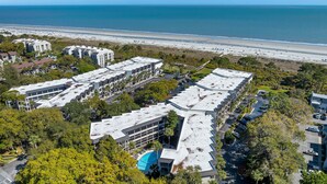 A coastal hotel with multiple buildings, a parking area, and a beach view. - Unmatched Views at Seaside Villa  Steps to the Sand (Hilton Head Island)