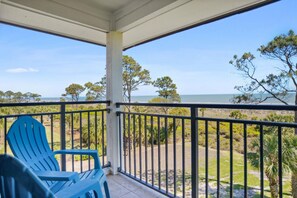 Enjoy the ocean view from this balcony with two comfortable chairs.