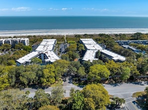 Un hôtel situé sur la côte, composé de plusieurs bâtiments, doté d’un parking et offrant une vue sur la plage.