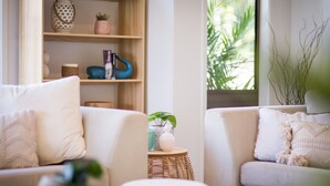 A living room with two sofas, a small side table, and a bookshelf with decorative items.