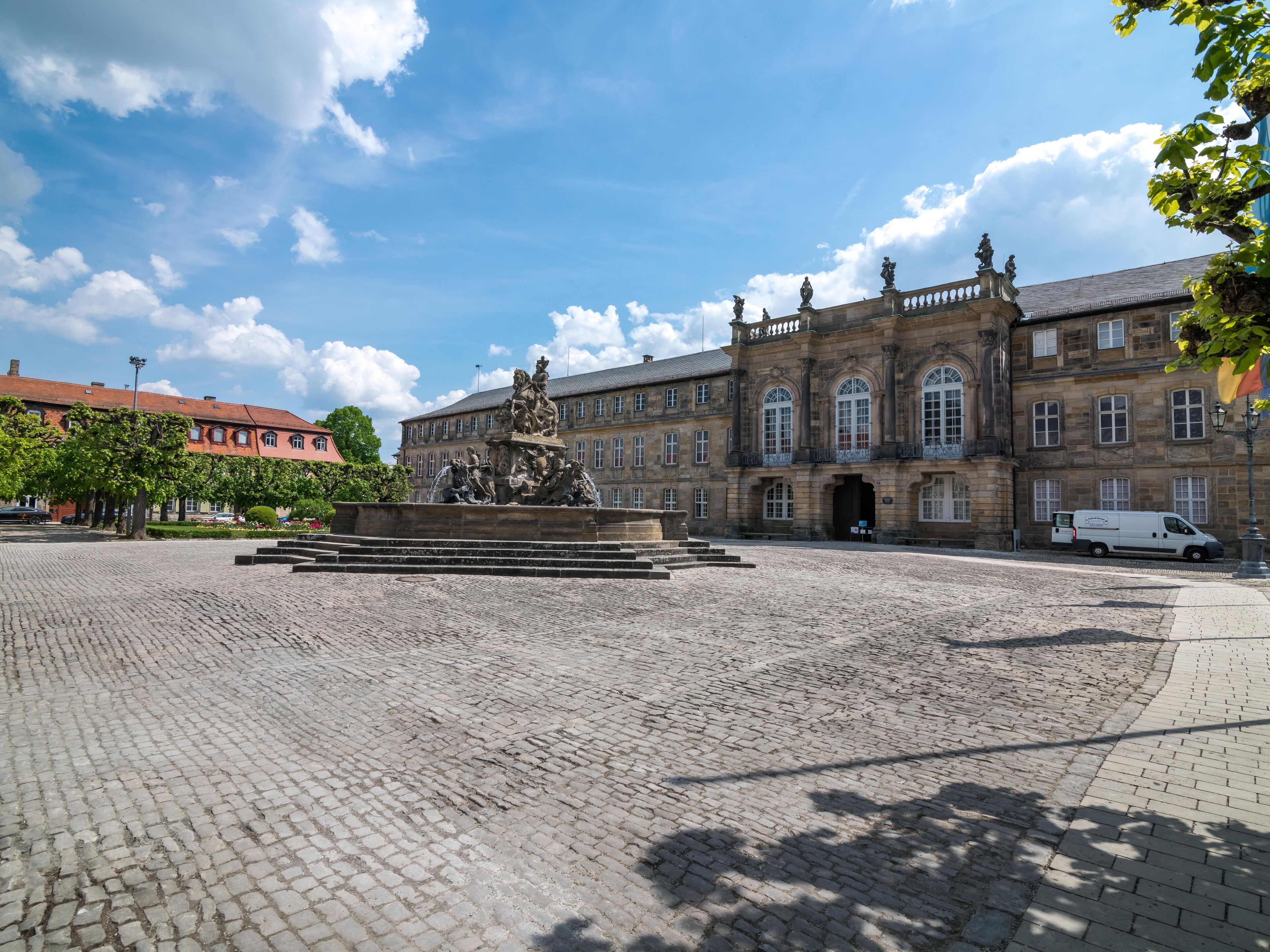 A historic building with a central fountain, cobblestone courtyard, and classical architecture.