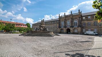 A historic building with a central fountain, cobblestone courtyard, and classical architecture.