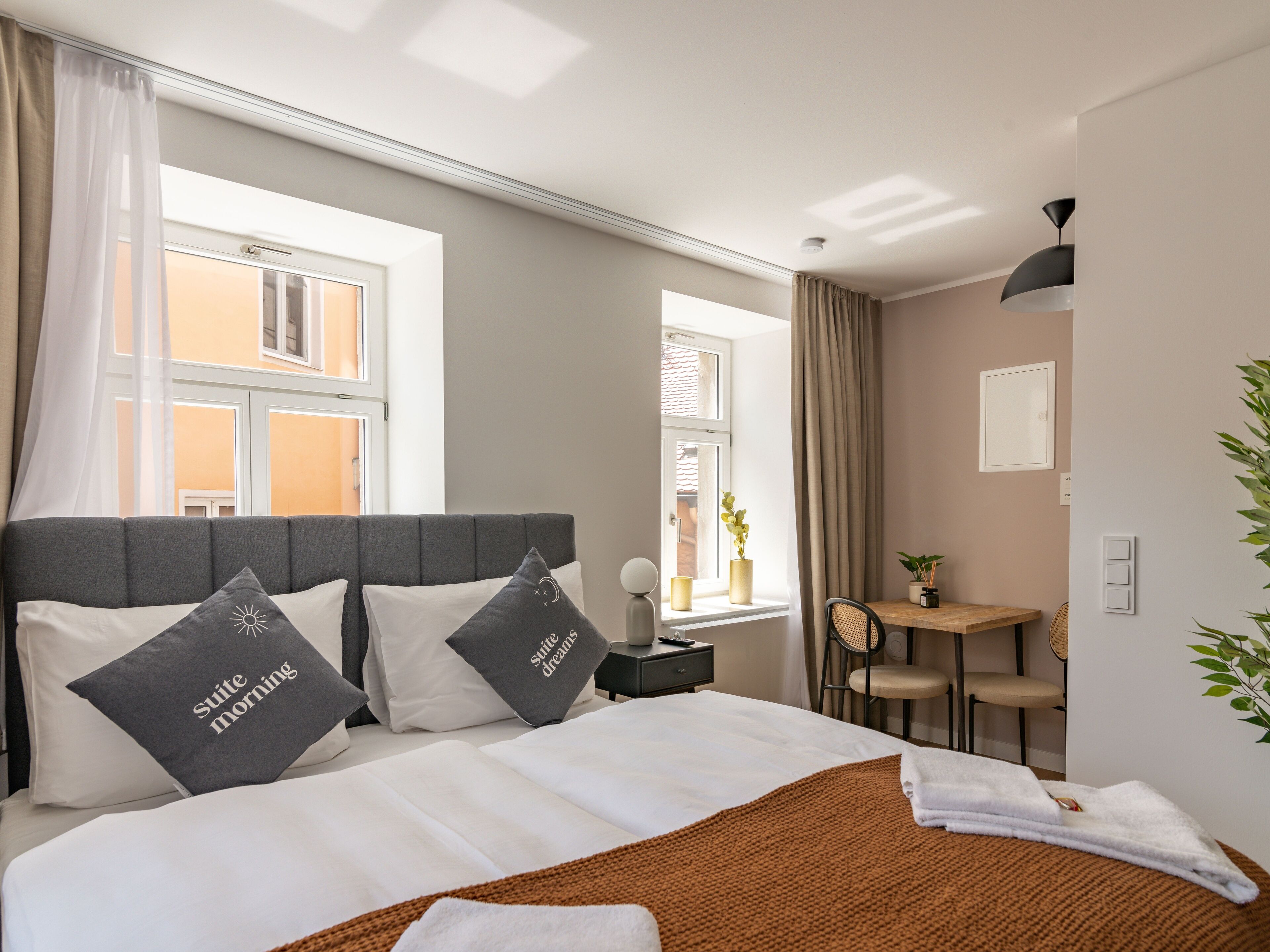 Habitació d'hotel amb un llit, una taula de treball i una finestra.