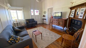 Un salon comprenant un canapé, une table basse, un téléviseur, une cheminée et un meuble en bois.