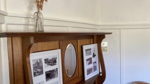 Une vitrine en bois contenant des photographies et un miroir.