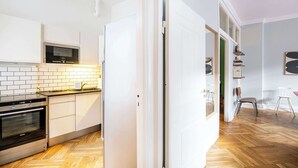 A modern kitchen with white cabinets, a microwave, and a built-in oven.