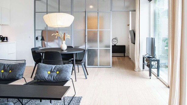 A modern interior with a dining area, a TV, and a large window. - Beach gardens 2BR by Daniel & Jacob's (Copenhagen)