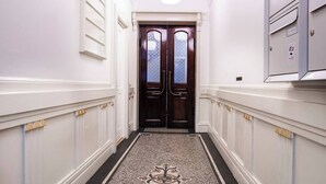 A hallway with a double door, white walls, and a patterned rug. - The Citadel 2 by Daniel&Jacob's (København)