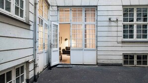 A narrow alleyway with a building entrance featuring a set of double doors and a small step leading up to the entrance. - The Citadel 2 by Daniel&Jacob's (København)