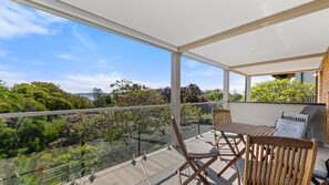 Enjoy a serene view of the lush garden and distant hills from this balcony.