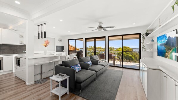 Relax in a spacious living area with a comfortable sofa, flat-screen TV, and stunning views of the surrounding landscape.