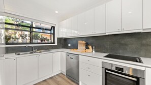 Enjoy cooking in this well-equipped kitchen with an oven, stainless steel dishwasher, and ample countertop space.