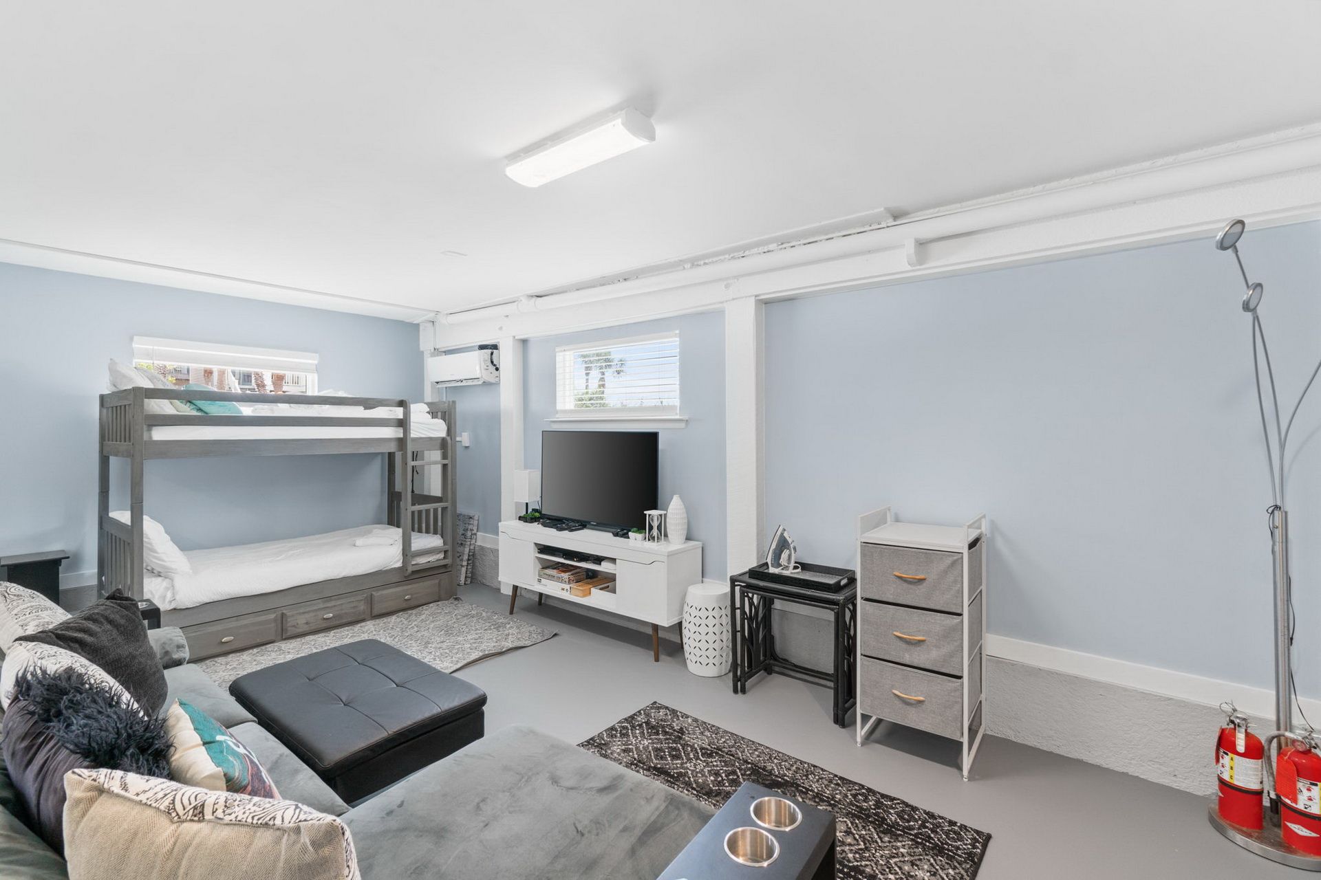 Un dormitorio moderno con literas, televisión, escritorio y armario.