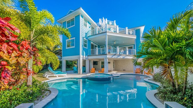 A two-story house with a swimming pool and a balcony. - Bluetique:  Monthly luxury beach home, private pool, rooftop deck (Holmes Beach)