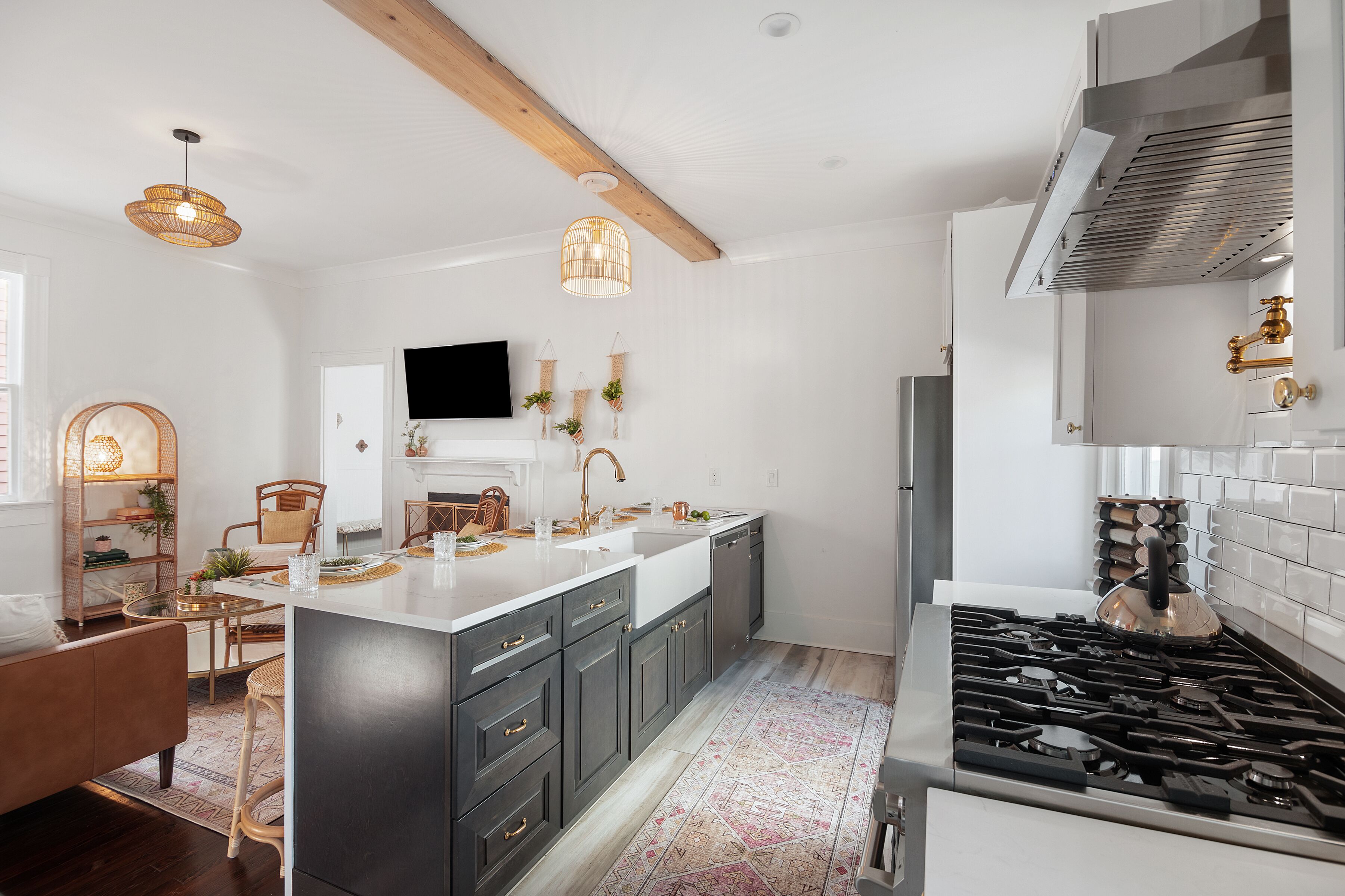 A modern kitchen with a central island, dark cabinetry, and a gas stove.