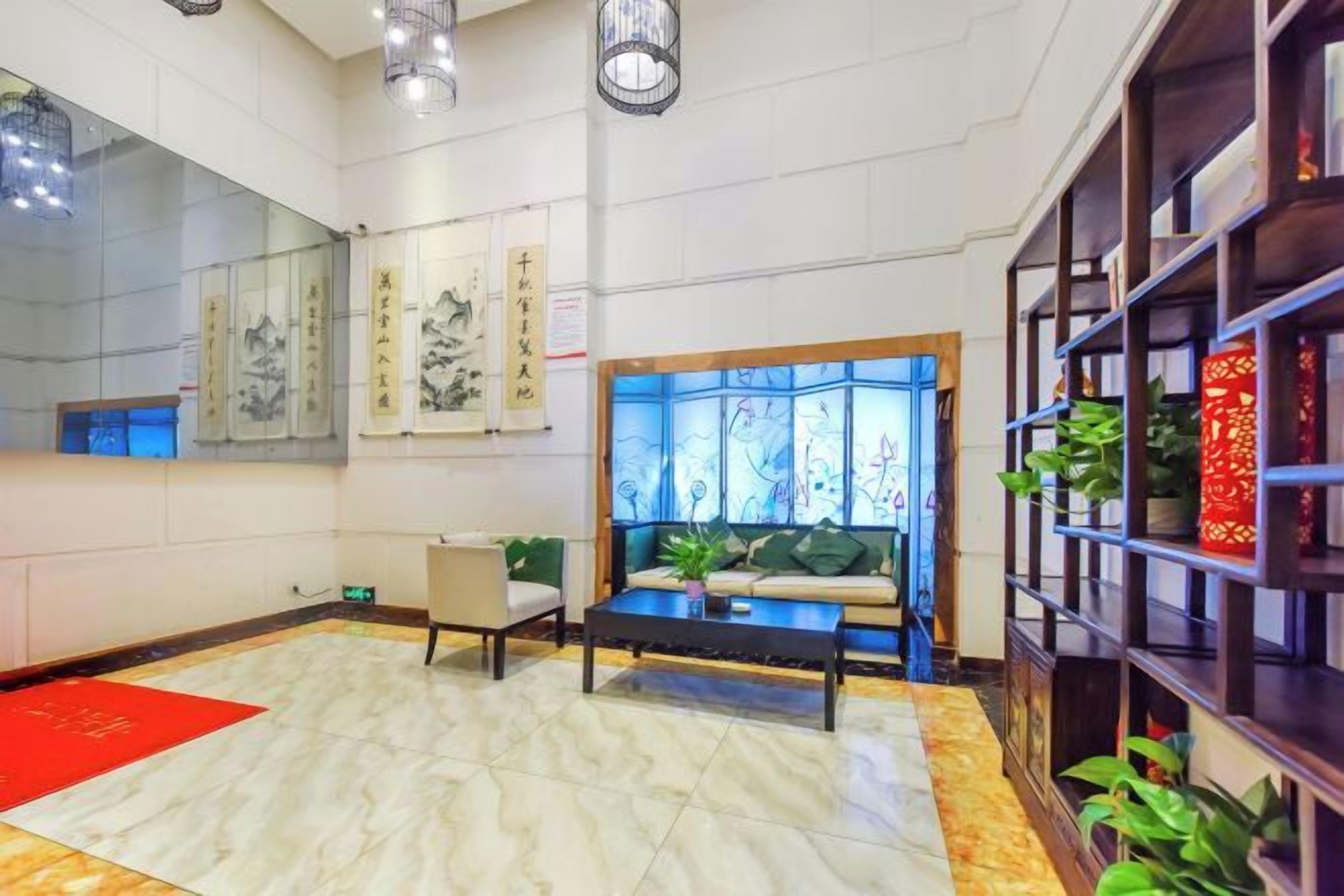 A hotel lobby with a reception desk, seating area, and decorative elements.