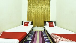 A twin room with two beds, a patterned rug, and a curtain. - OYO Home 90492 Sena Homestay (Pokok Sena)