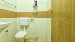 A small bathroom with a toilet, sink, and a shelf with toiletries. - OYO Home 90492 Sena Homestay (Pokok Sena)