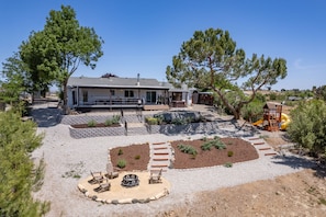 A house with a covered patio, outdoor seating, and a play area for children.