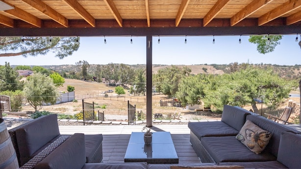 Un espacio de estar al aire libre cubierto con vistas a un paisaje rural.