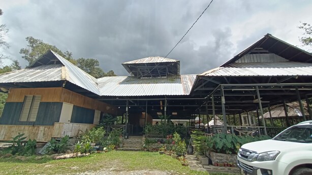 A two-story building with a corrugated metal roof and a covered porch area. - Hotel O Flinstone Lodge (Kota Belud)